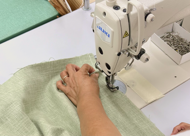 image of worker using sewing machine to make custom pillows for Kreative Pillows