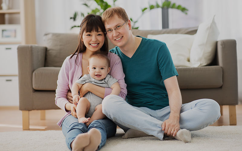 image of interracial couple holding their baby